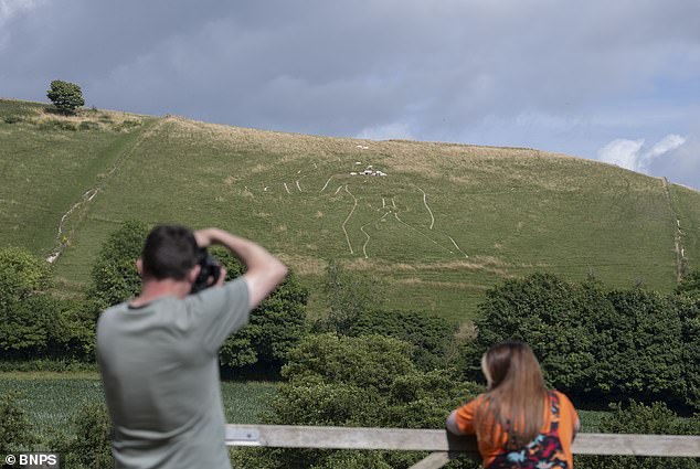 National Trust volunteers restore 180-foot Cerne Abbas Giant with fresh chalk.